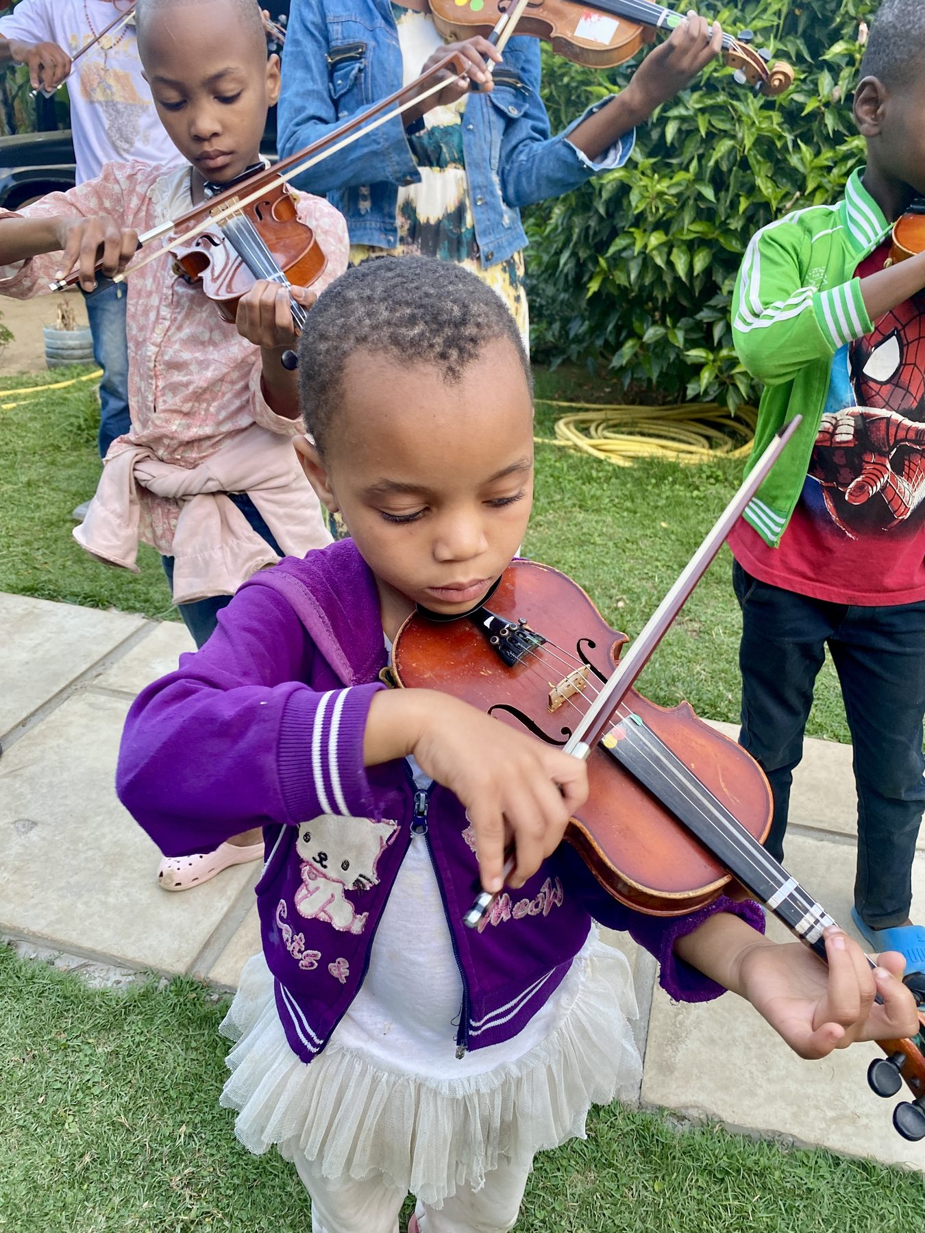 Young violinist at Kwetu Nyumbani Kids, Arusha